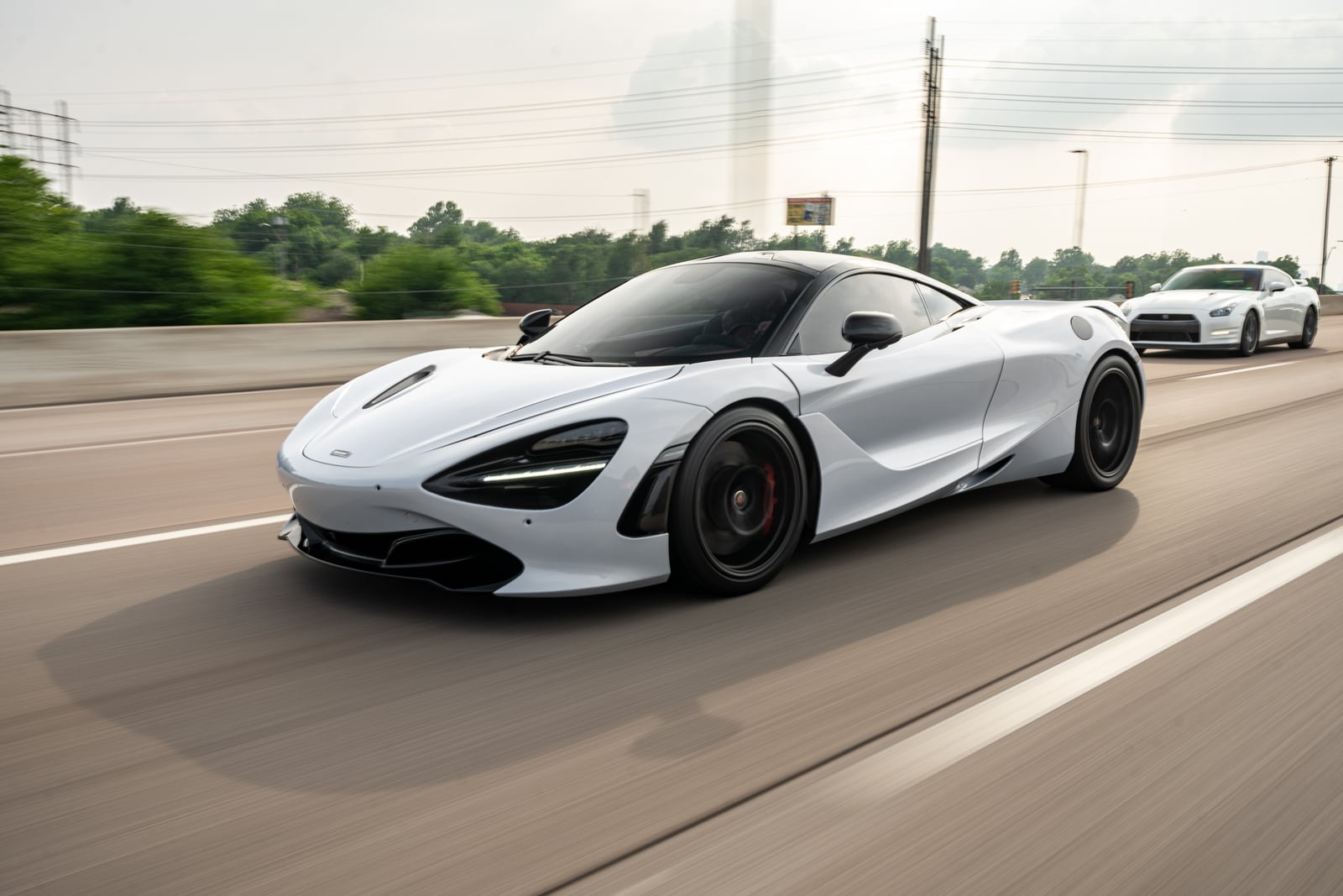 A white McLaren on the open road during the memorial cruise.